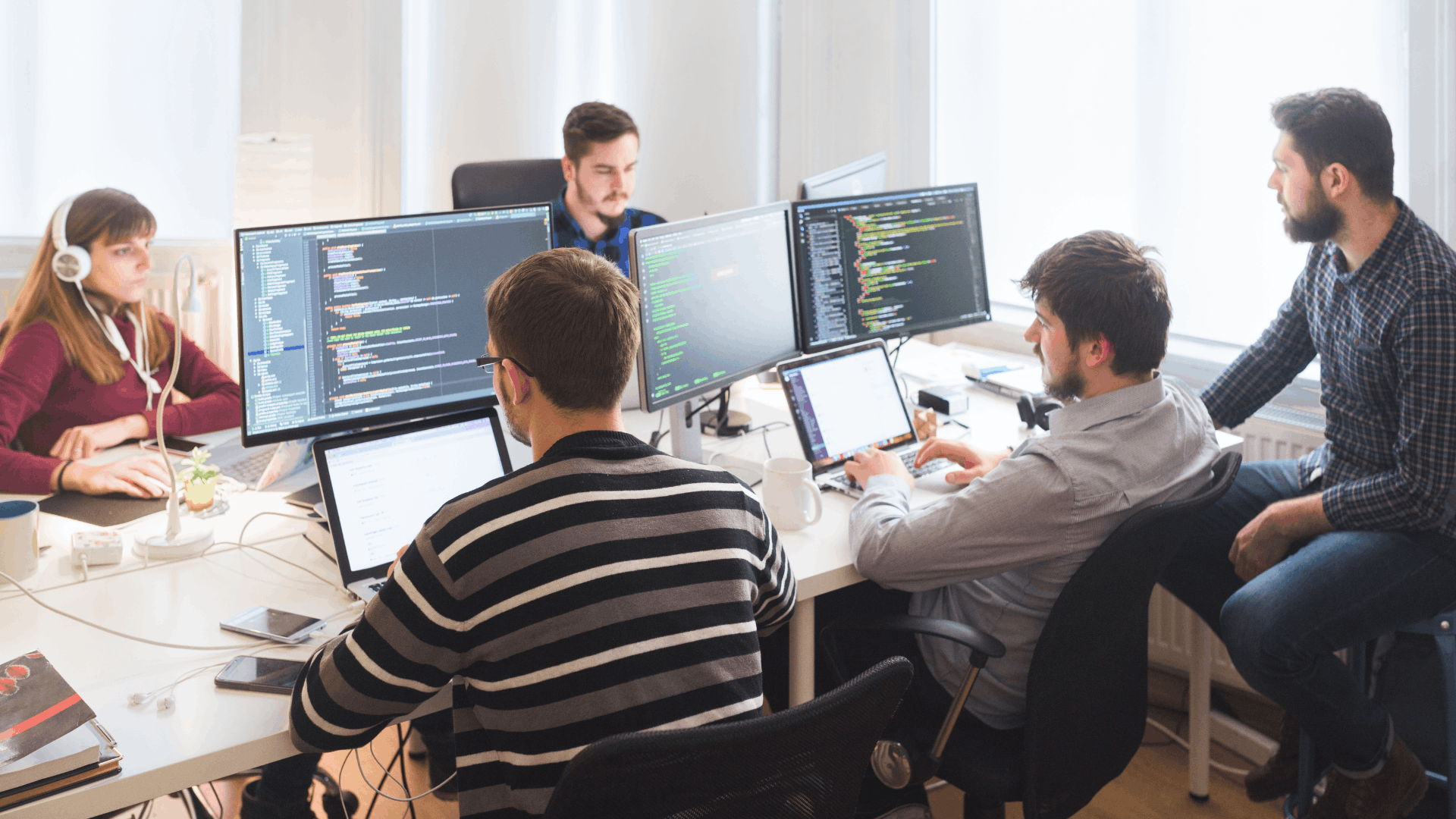 Softwareentwicklungsteam arbeitet gemeinsam an Anforderungen, Code und Umsetzung im Büro