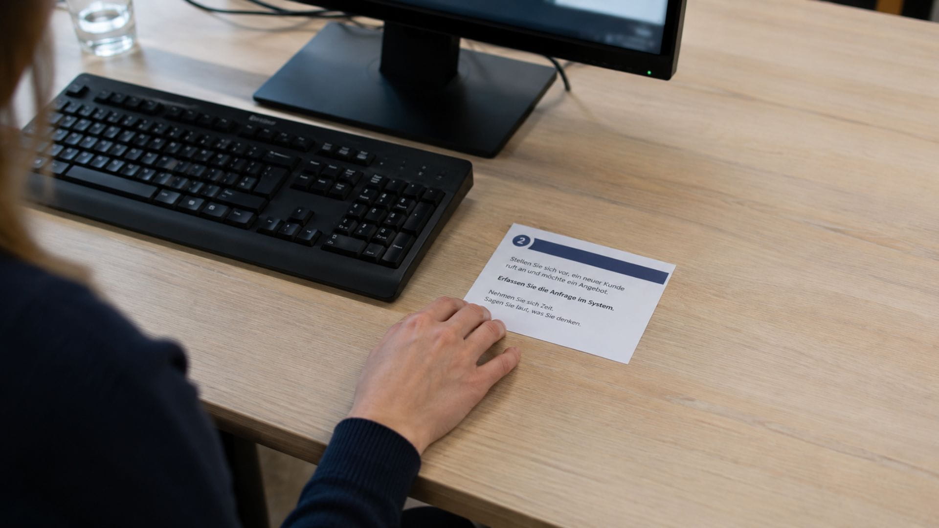 Aufgabenkarte liegt neben der Tastatur einer Testperson