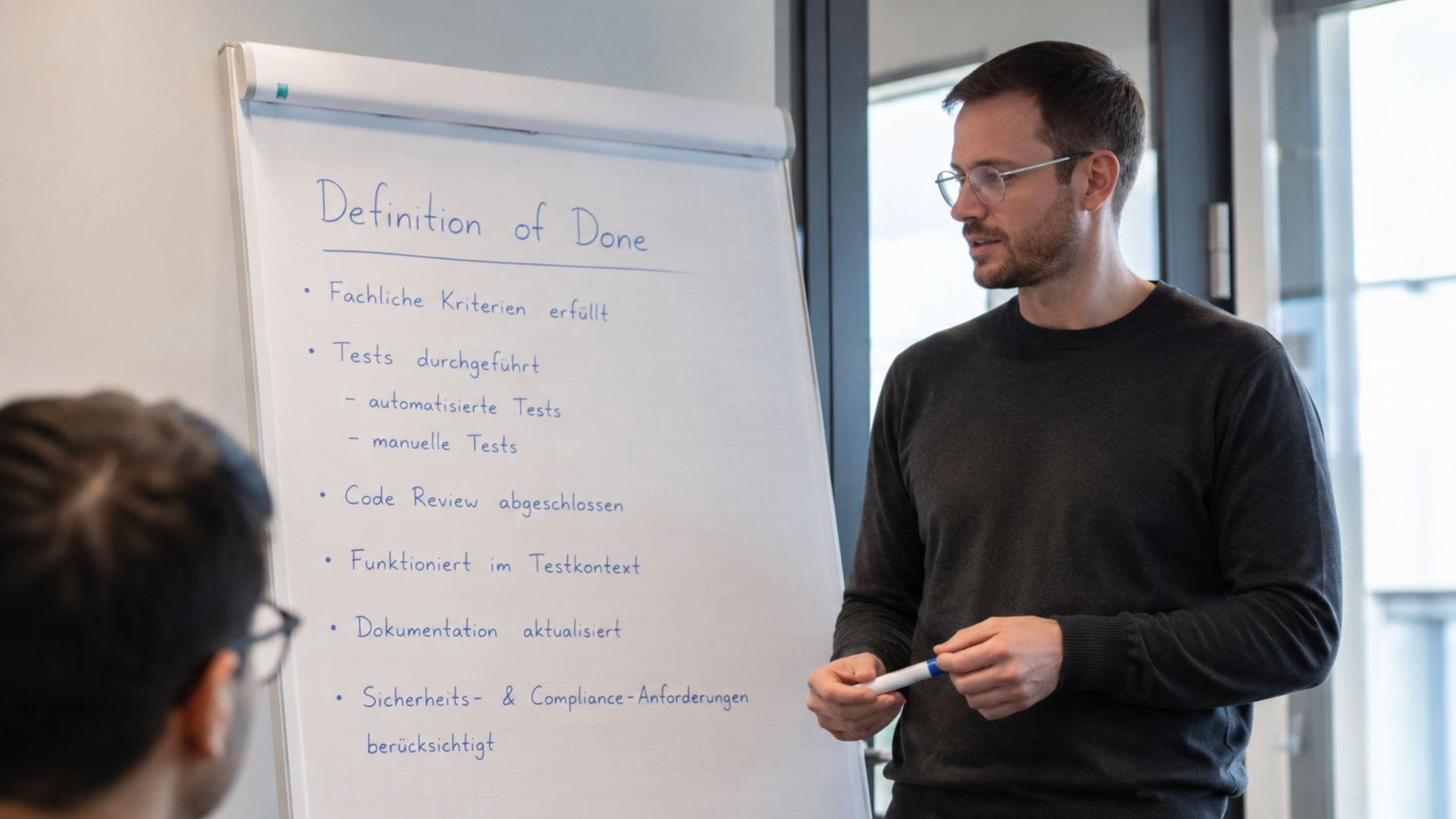 Entwicklungsteam bespricht die Definition of Done in der agilen Softwareentwicklung an einem Flipchart